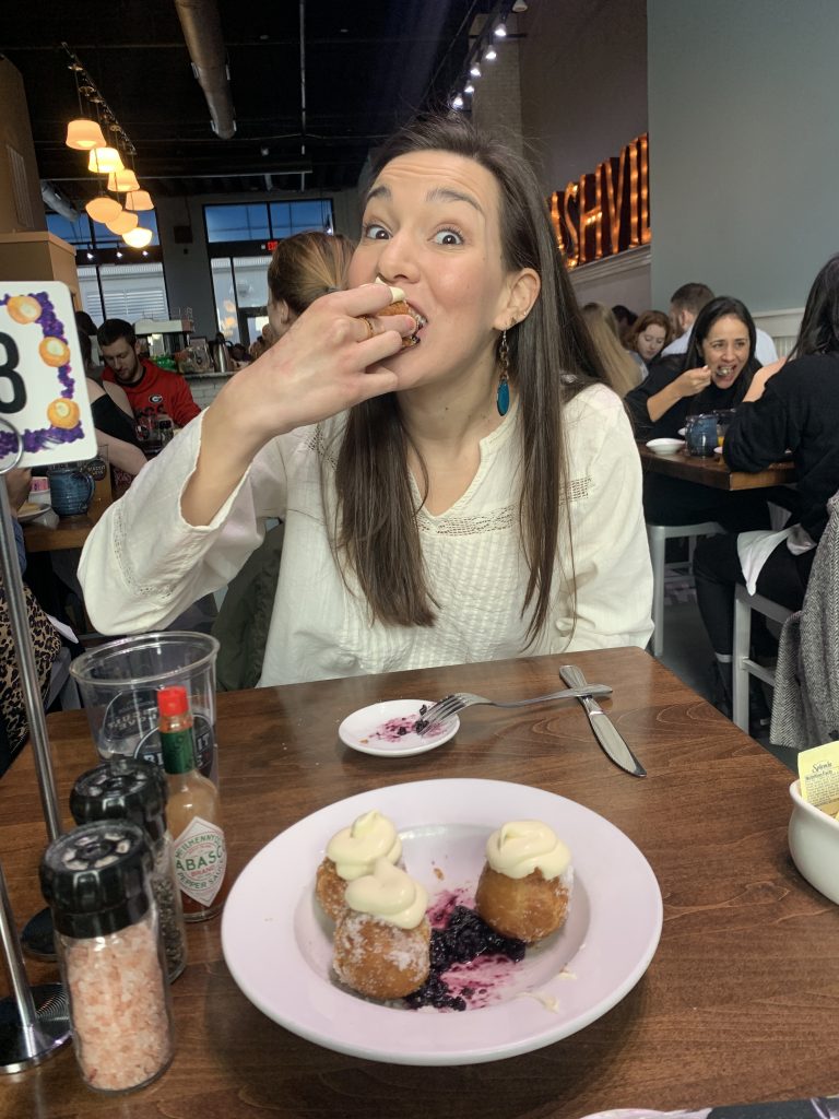 girl eating fried donut biscuit at restaurant