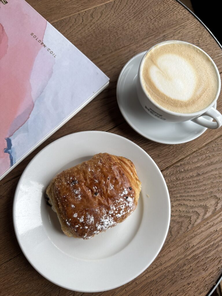 croissant coffee and planner at a cafe